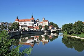 Schloss Neuburg an der Donau Schloss Neuburg und die Donau, die sich rechts am Schloss vorbeischlängelt. Links ist die Promenade und links das begrünte Ufer zu sehen.