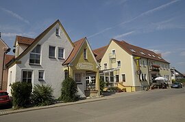 Ein Gebäudekomplex mit zwei großen Häusern des Gasthof und Metzgerei Kleemann. Auf der linken Seite ein weißes dreistöckiges Haus mit der Aufschrift Gästehaus Kleemann. daneben ein Vordach aus Glas. Daran schließt sich ein langes dreistöckiges Haus mit gelber Fassade an.